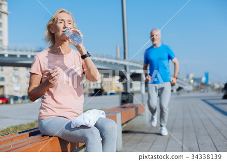 Athletic woman drinking water after a morning run 34338139