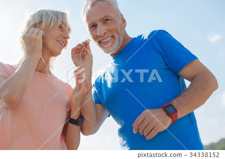 Elderly couple listening to music in one pair of 34338152