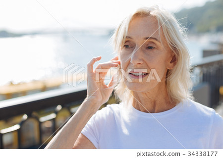 Close up of senior woman tidying up her hair Close up of senior woman tidying up her hair 34338177