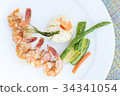 grilled shrimps or skewer on plate with salad 34341054