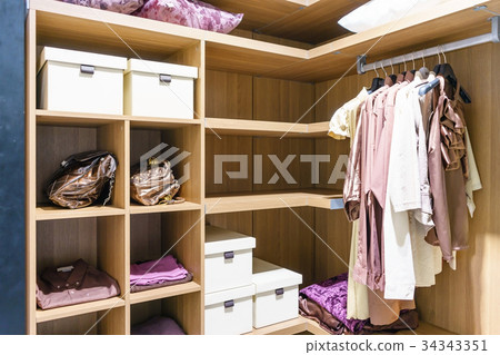 wooden wardrobe with clothes hanging on rail wooden wardrobe with clothes hanging on rail 34343351
