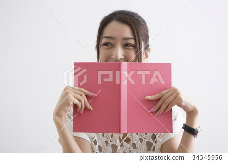 A woman who hides her face with a book A woman who hides her face with a book 34345956