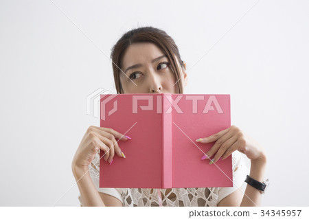 A woman who hides her face with a book A woman who hides her face with a book 34345957