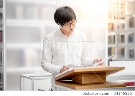 Asian university student reading book in library Asian university student reading book in library 34346530