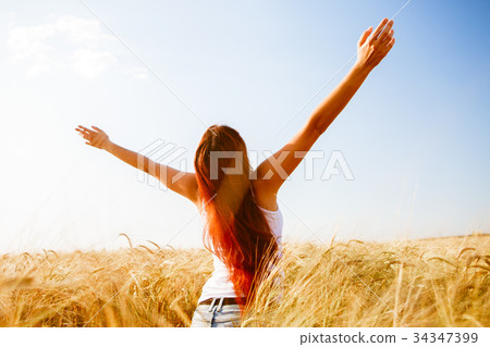 Photo from back of woman with arms raised Photo from back of woman with arms raised 34347399