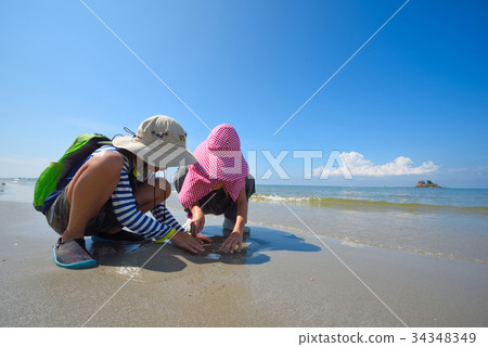 Two children explore at the beach on a clear day. Two children explore at the beach on a clear day. 34348349
