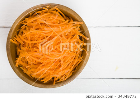 Grate  carrots in a bowl 34349772