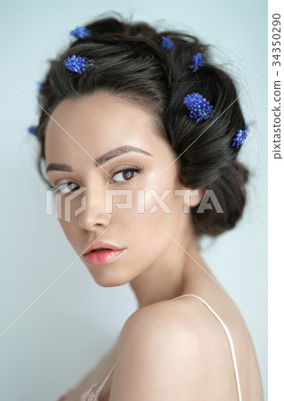 Beautiful young woman with blue muscari in her hair Beautiful young woman with blue muscari in her hair 34350290