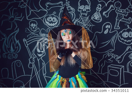 Girl in a witch costume on dark background with Girl in a witch costume on dark background with 34351011