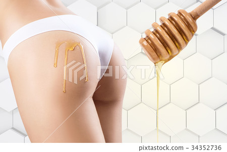 Honey flows down on woman buttocks. 34352736