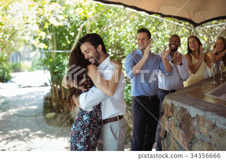 Friends embracing each other at counter Friends embracing each other at counter 34356666