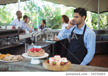 Waiter talking on mobile phone 34356904