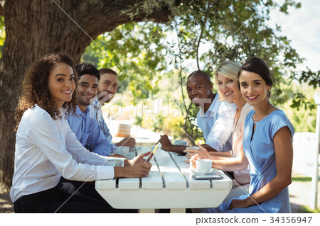 Group of friends sitting together in outdoor restaurant 34356947