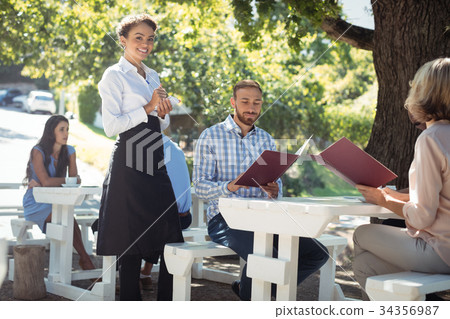 Smiling waitress taking order from customer in the restaurant Smiling waitress taking order from customer in the restaurant 34356987