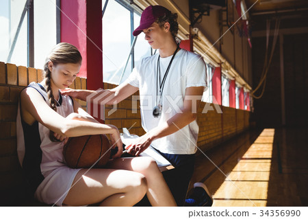 Male coach talking to female basketball player 34356990