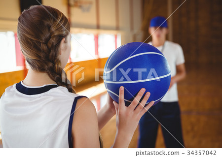 Female basketball player practicing with male coach 34357042