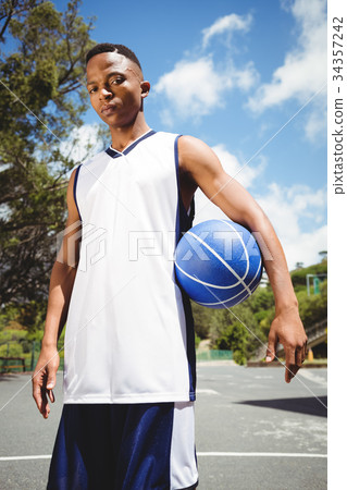 Portrait of male teenager holding ball 34357242