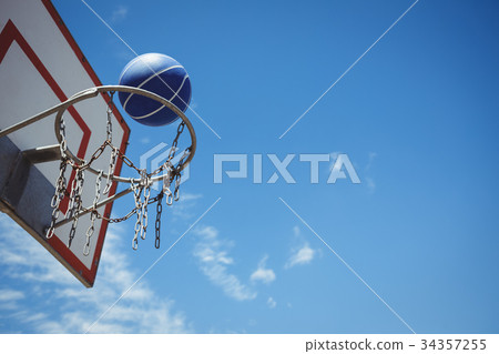 Low angle view of blue basketball in hoop Low angle view of blue basketball in hoop 34357255