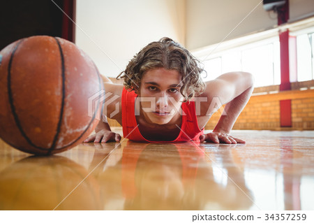 Portrait of male basketball player exercising Portrait of male basketball player exercising 34357259