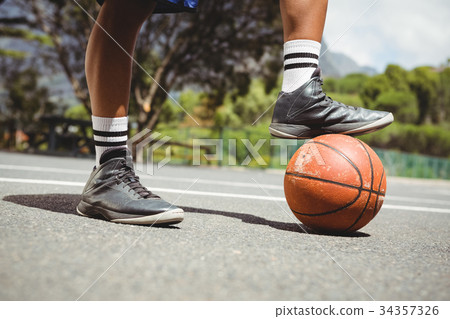 Close up of man standing with one leg on basketball 34357326