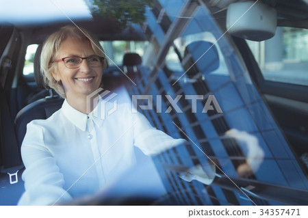 Smiling businesswoman driving car Smiling businesswoman driving car 34357471