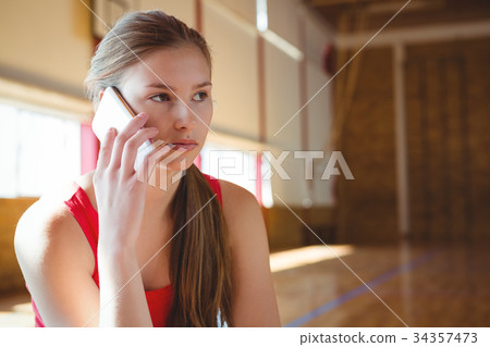 Close up of female basketball player talking on phone Close up of female basketball player talking on phone 34357473