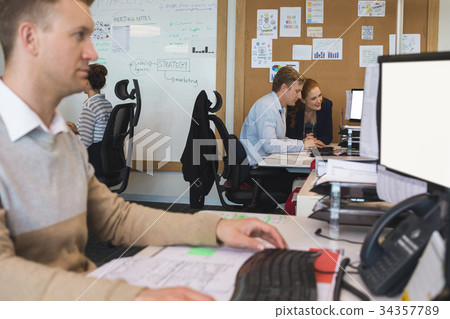 Young coworkers discussing while working in office 34357789