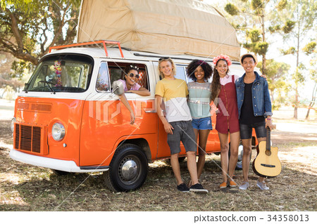 Portrait of smiling friends standing by camper van Portrait of smiling friends standing by camper van 34358013