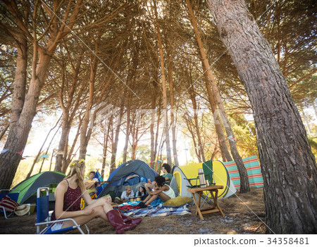 Friends sitting together at campsite 34358481