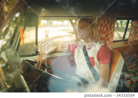 Smiling man sitting in camper van Smiling man sitting in camper van 34358584