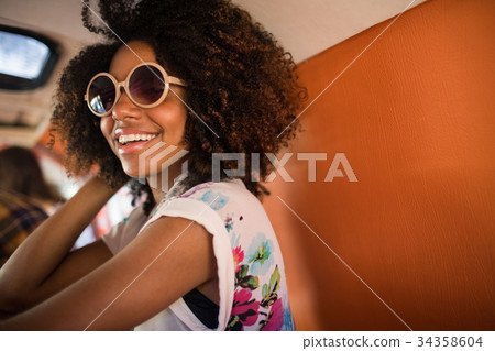 Young woman wearing sunglasses in camper van Young woman wearing sunglasses in camper van 34358604