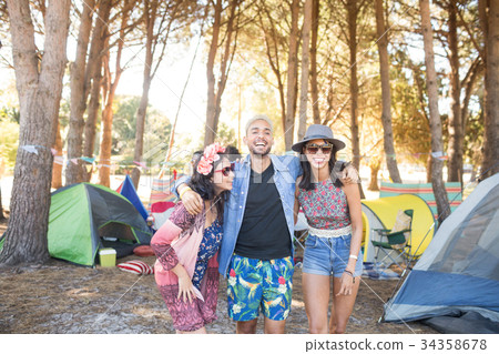 Happy friends standing together at campsite Happy friends standing together at campsite 34358678