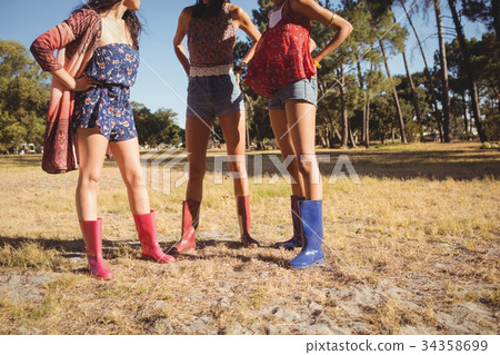 Low section of female friends standing on field Low section of female friends standing on field 34358699