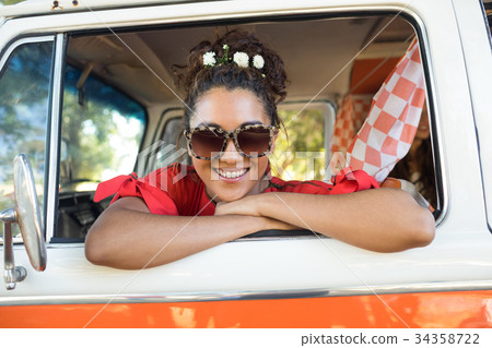 Portrait of smiling woman looking through camper van window 34358722
