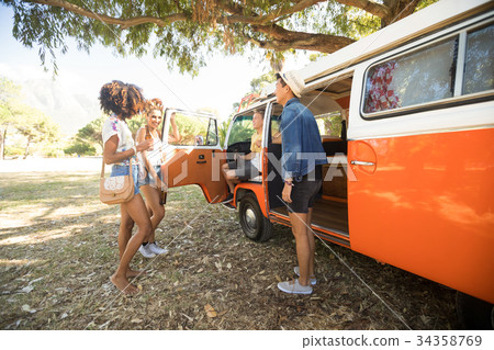 Young friends standing by camper van at campsite 34358769