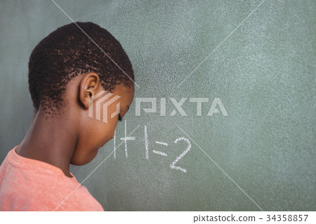 Boy standing by chalkboard Boy standing by chalkboard 34358857