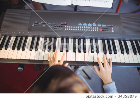Cropped image of girl playing piano 34358879
