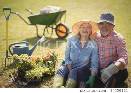 Smiling senior couple sitting together in garden 34359161