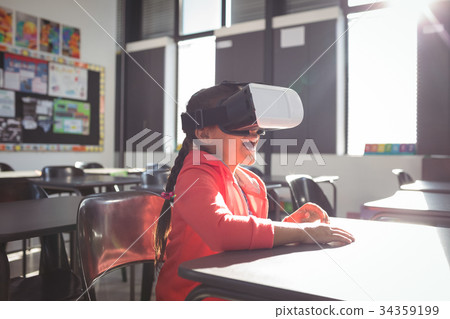 Girl using virtual reality glasses in classroom Girl using virtual reality glasses in classroom 34359199