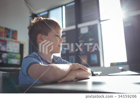 Boy looking away while sitting in classroom 34359206