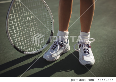 Low section of girl with tennis racket 34359277