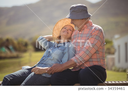 Smiling senior couple relaxing together on bench 34359461