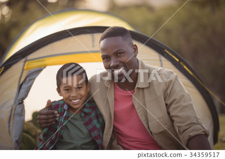 Father and son sitting in park 34359517