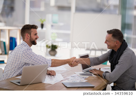 Business partners shaking hands in the office 34359610