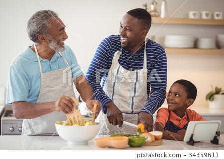 Multi-generation family preparing food in kitchen 34359611