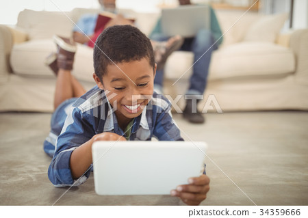 Boy using digital tablet in living room 34359666