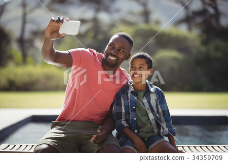 Father and son taking selfie with mobile phone 34359709