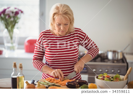 Senior woman chopping vegetables 34359811