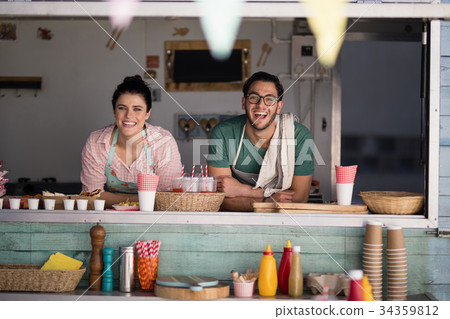 Portrait of waiter and waitress leaning at counter 34359812