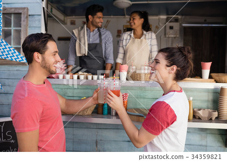 Couple toasting a glasses of juice at counter 34359821